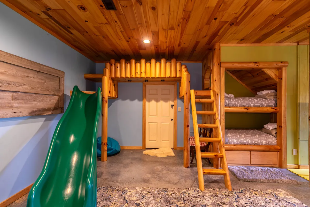A close-up on the bunk beds and slide, this image highlights the imaginative sleeping and play spaces for children. The wooden ladder and ceiling, as well as the cheerful green slide, inspire thoughts of bedtime stories and playful afternoons.